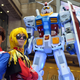 Cosplayers in Hong Kong pose in front of a giant Gundam.